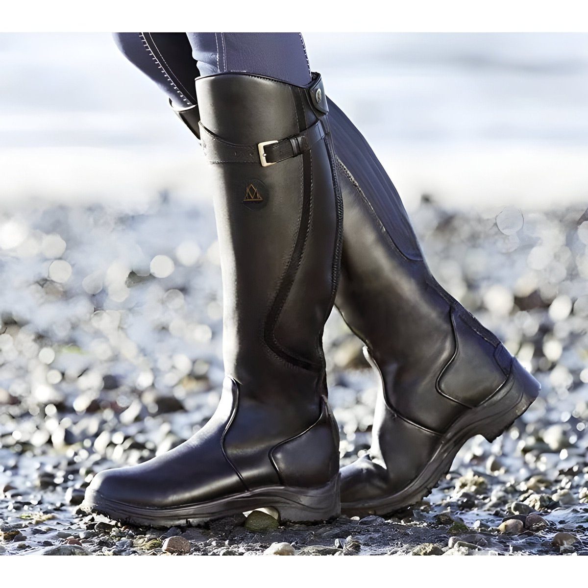 Black knee-high leather riding boots, worn